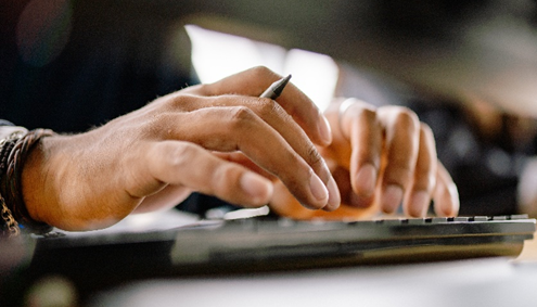 A person’s hands on a computer keyboard